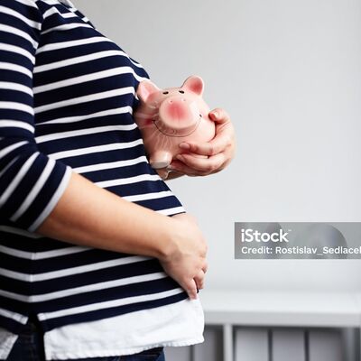 Bild vergr&ouml;&szlig;ern: Pregnant woman with piggy bank in the office